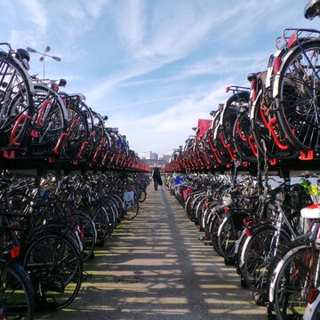 Distant view of a man walking between a row of parked bicycles, Amsterdam, The Netherlands