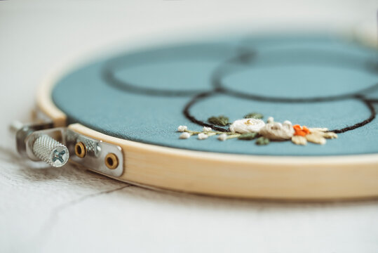 Close-up of an embroidery hoop with a floral motif on a table