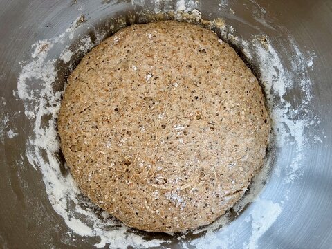 Close-up overhead view of Homemade brown bread dough in a bowl resting and rising