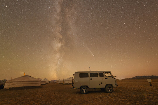 Milky Way over a parked vehicle and row of Mongolian yurts in the Gobi Desert, Western Mongolia, Mongolia