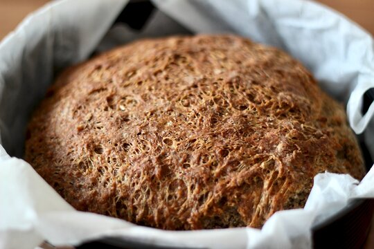 Close-up of a Rustic rye sourdough loaf in a baking tin lined with baking paper