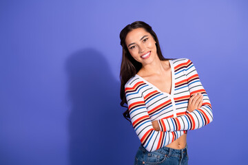 Young woman in striped sweater smiles against violet background for fashion lifestyle image