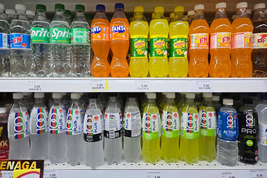 Penang, Malaysia: Nov 06, 2025: Rows of various bottled beverages including F&N Orange, Sprite, Kickapoo Joy Juice, and 100 Plus isotonic drinks displayed in a modern grocery store aisle.