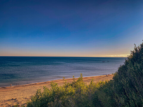 Mediterraner Strand mit Sonne, kleinem Strauch und Mittelmeer
