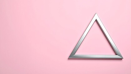 A silver triangular frame rests on a soft pink backdrop, appearing centered and slightly tilted. Shadows and subtle color variations create depth