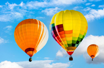 Fototapeta premium Colorful hot air balloons flying in blue sky with clouds