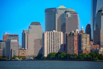 Fototapeta premium Abstract urban background featuring a dense cluster of modern skyscraper facades with geometric window patterns in golden evening light, New York City.