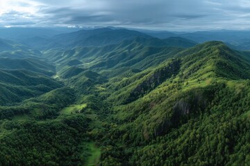 Obraz premium Majestic Green Mountains Stretch Under a Dramatic Cloudy Sky