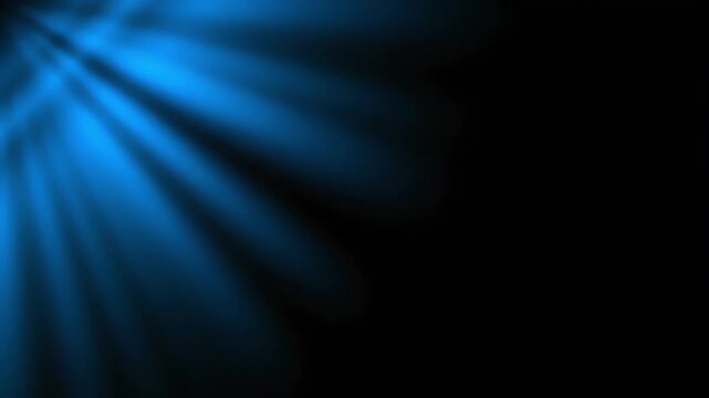 Abstract background with blue light rays shining from the left corner against a dark backdrop with a shallow depth of field.