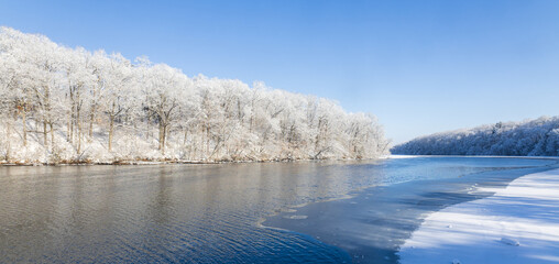 Snow-covered forest alongside a river
