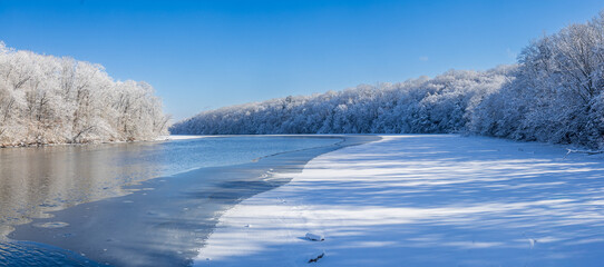 Snow-covered trees surround a lake