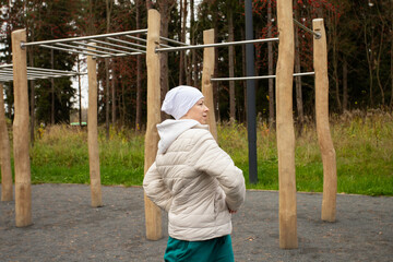 Female patient practicing outdoor fitness, concept of cancer awareness, healing through sport, and motivation to stay strong.