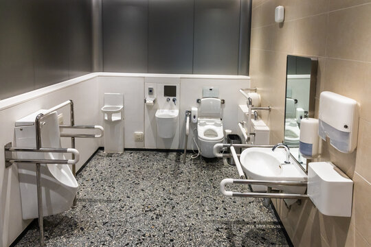 Comprehensive public generic disability friendly restroom toilet sanitary with hand rails, bars and aids.