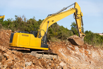 Yellow construction excavator works on a construction site