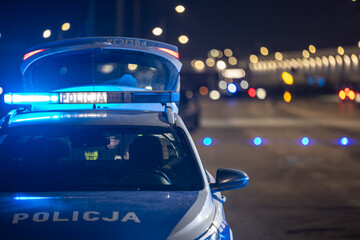 Policyjny radiowóz z reflektorem w nocy na ulicy © FotoDax