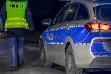 Policyjny radiowóz z reflektorem w nocy na ulicy © FotoDax