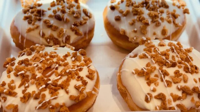 Cheesecake And Chocolate Donuts On Counter, Lined In Neat Trays With Glossy Glazes, Crumbled Topping And Delicate Sprinkles Bustling Bakery Vibe Suggesting Morning Rush And Retail Sale.