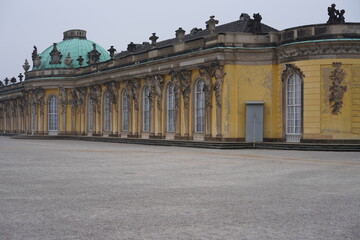 Obraz premium Panoramablick auf Schloss Sanssouci im Winter mit grüner Kuppel und Winterschutz für Statuen, Potsdam