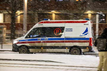 Karetka medyczna w śniegu zimą na sygnale alarmowo © FotoDax