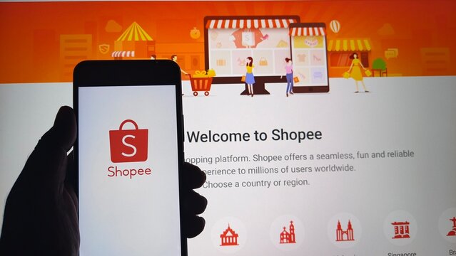 Hand holding smartphone with Shopee app open on screen