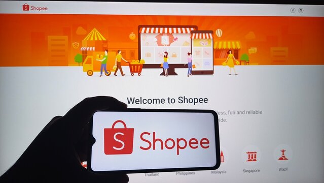 Hand holding smartphone with Shopee app open on screen