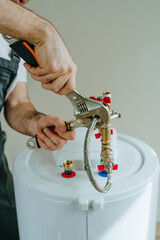 Man fixing water heater using wrench