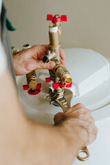 Man plumbing fittings of water heater using wrench