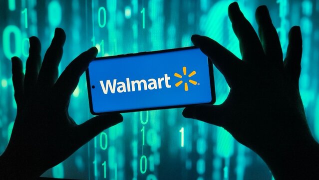 Hands holding smartphone displaying walmart logo against binary code