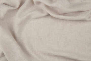 Fototapeta premium Soft draped beige linen background. Natural eco friendly fabric texture with draperies in left side