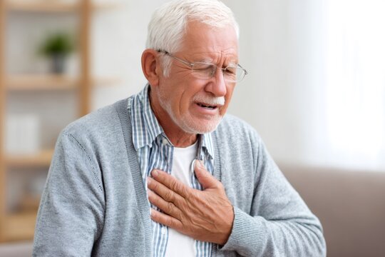Senior man feeling chest pain holding heart