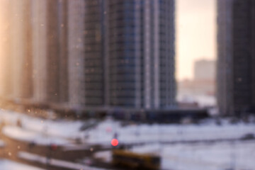 Naklejka premium Nighttime urban snow scene, Snowcovered city with warm lights and misty twilight setting