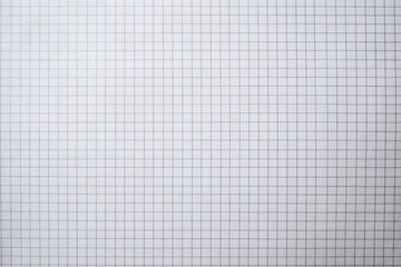 Blank grid paper ready for drawing or writing in a classroom or office space during daytime
