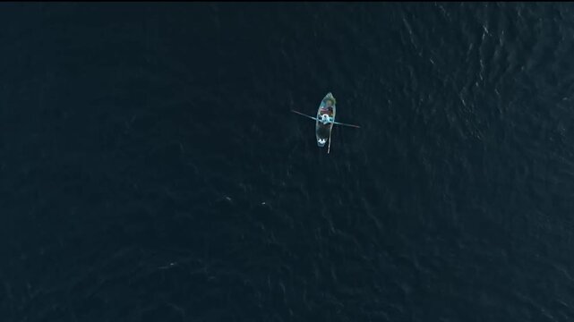 Bird's Eye Aerial View of a Traditional Rowing Boat Sailing on the Deep Blue Water of the Nile River in Aswan, Egypt