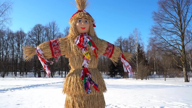 Traditional straw effigy in winter park under blue sky