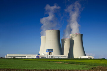 Nuclear energy concept. Atomic power station generating electricity with zero carbon emissions on a sunny day.