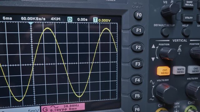A close-up of an oscilloscope screen shows a yellow sine wave measurement on a grid. This visual represents signal analysis, scientific research, and engineering diagnostics.