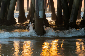 Sunset Waves Clash Against Pier on Glowing Horizon