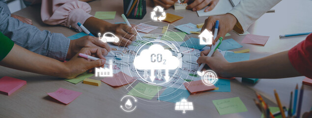 A diverse group collaborates on environmental sustainability, focusing on CO2 emissions with...