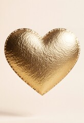 Golden metallic heart shape with textured foil surface on neutral background for romantic designs, Valentine's Day cards, wedding invitations, love concepts