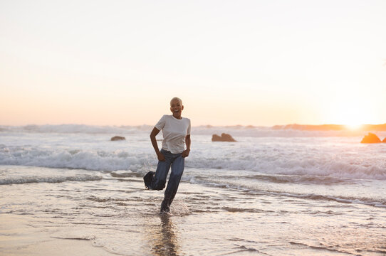 Woman running in ocean waves enjoying sunset