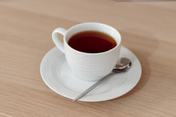 Cup of tea on saucer with spoon