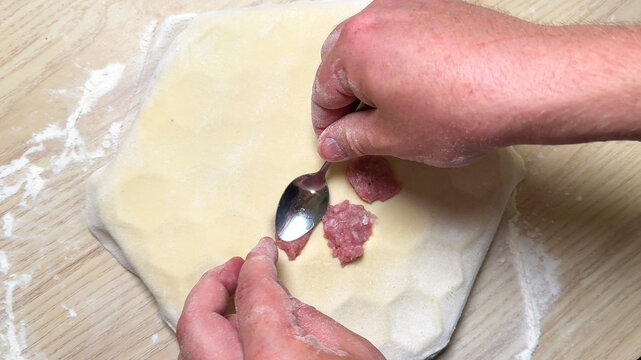 Hands fluently crafting Russian pelmeni, wintery culinary tradition, savory dough art, Slavic kitchen magic, festive Maslenitsa preparation