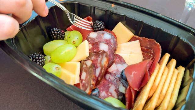 Charcuterie indulgence with juicy green grapes, savory cured meats, and crackers; ideal for Bastille Day feasts or Hygge picnics
