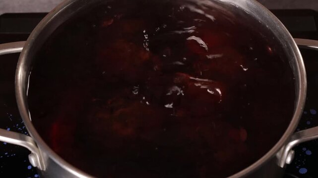 Beets are cooked in boiling water in a saucepan on the stove.
