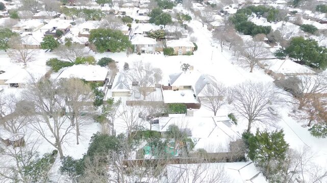 Subdivision east of Mockingbird Lane displays tightly packed homes with snow-laden roofs and yards. Evergreen accents and parked vehicles punctuate Winter Storm Fern white terrain, Coppell, TX