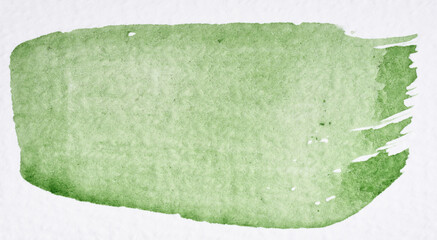 A single, broad brushstroke of light green watercolor paint is applied to white paper © nndanko