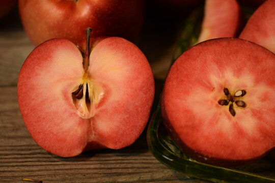 Baya Marisa apples on wooden background, red pulp and skin apples closeup.