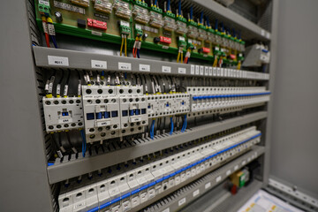 Contactors and circuit breakers in a cabinet with cabling.