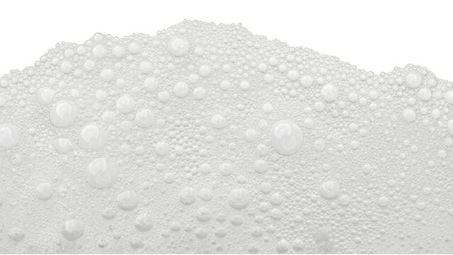 Macro shot of white foam texture with glossy water droplets on a dark solid surface