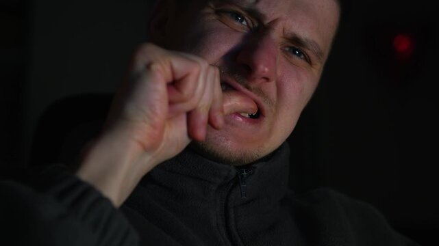 A man is nervous and biting his fingernails.
This is the behavior of someone who is stressed.
A man bites dirty fingernails contaminated with germs.
